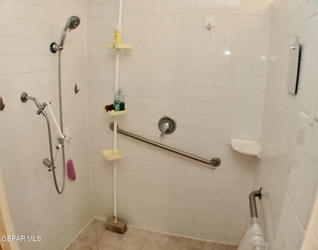 bathroom with tile patterned flooring and a tile shower