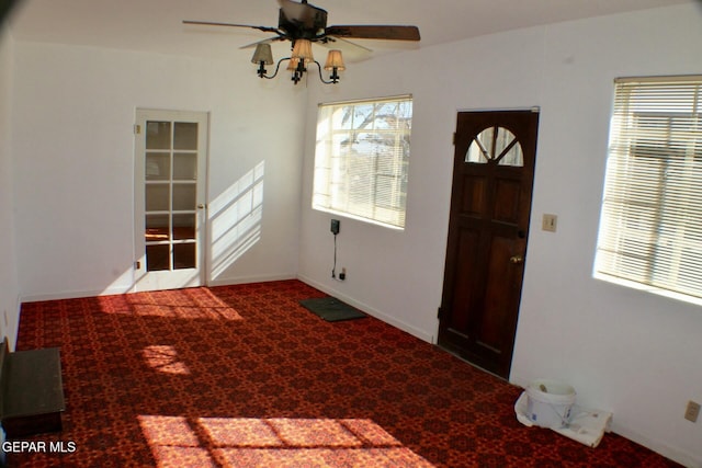 foyer featuring plenty of natural light, ceiling fan, and carpet floors