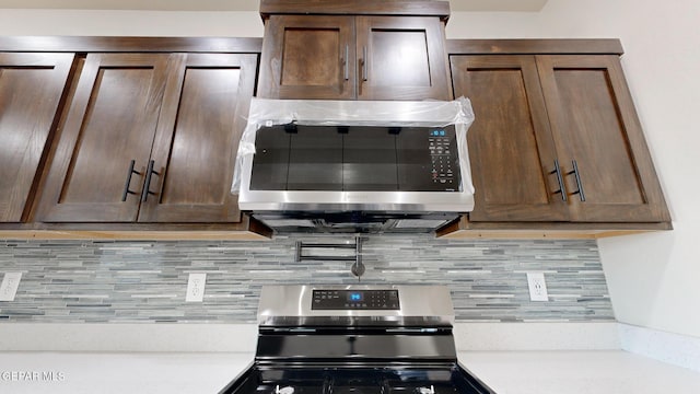 kitchen with backsplash, stainless steel appliances, and dark brown cabinetry