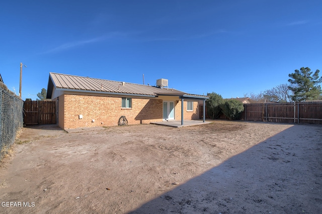 rear view of property featuring central air condition unit and a patio