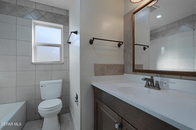 bathroom featuring tile patterned flooring, vanity, toilet, and tile walls