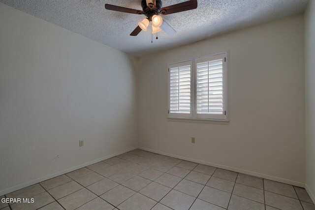 tiled empty room featuring ceiling fan and a textured ceiling