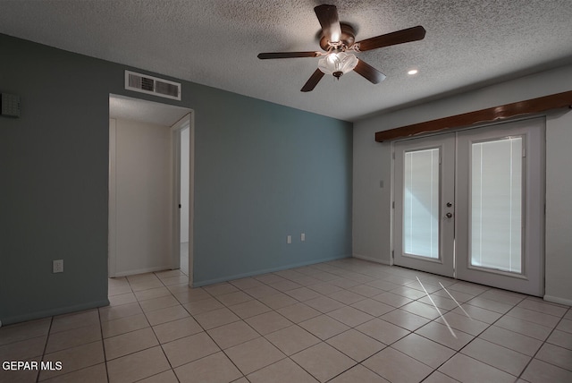 tiled empty room featuring ceiling fan, french doors, and a textured ceiling