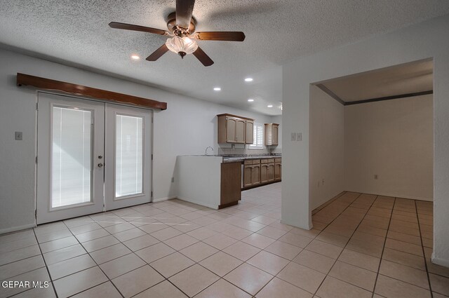 kitchen with ceiling fan, light tile patterned floors, a textured ceiling, and french doors