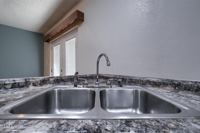 room details with sink and a textured ceiling