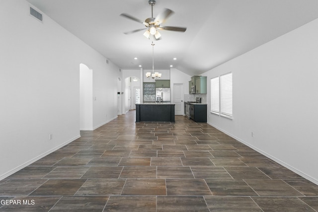 unfurnished living room with vaulted ceiling and ceiling fan with notable chandelier