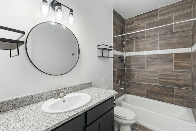 full bathroom with tile patterned floors, tiled shower / bath combo, toilet, and vanity