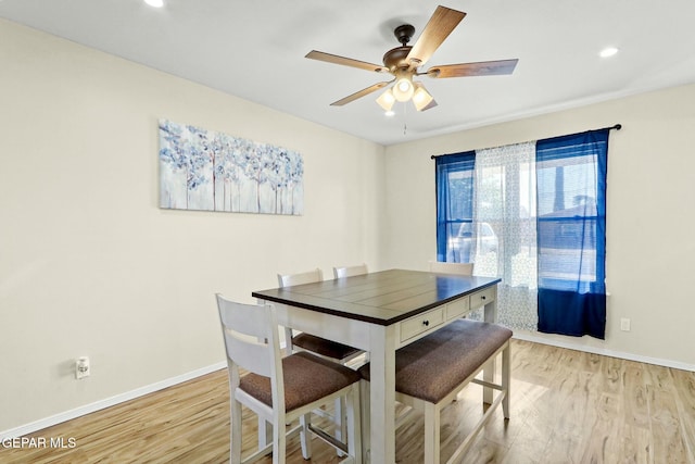 dining space with ceiling fan and light hardwood / wood-style flooring