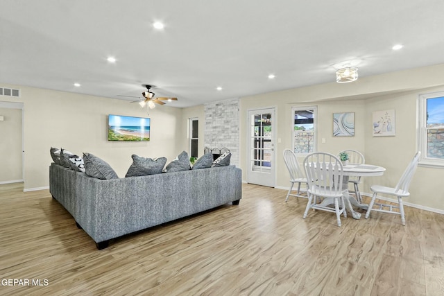 living room featuring ceiling fan and light hardwood / wood-style flooring