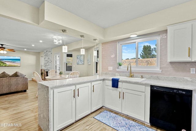 kitchen featuring sink, light wood-type flooring, black dishwasher, white cabinetry, and kitchen peninsula