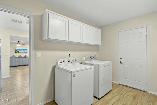 laundry room featuring cabinets, light wood-type flooring, washer and clothes dryer, and ceiling fan