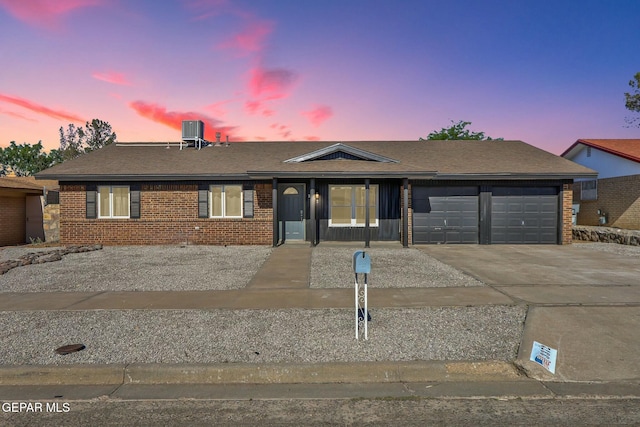 single story home with cooling unit and a garage