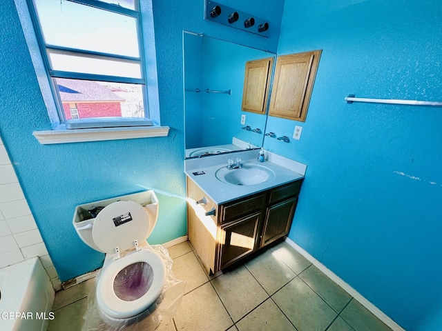 bathroom with a bathing tub, tile patterned flooring, vanity, and toilet