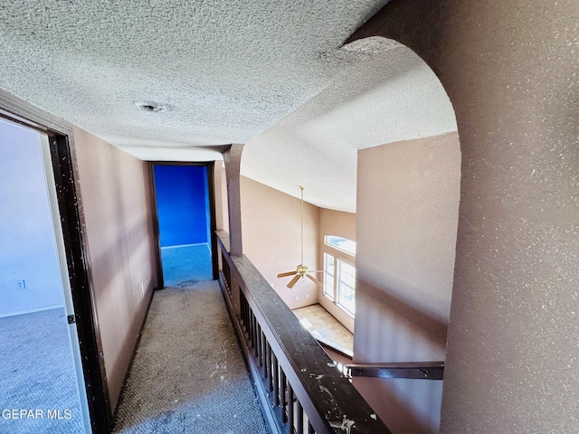 corridor featuring carpet and a textured ceiling