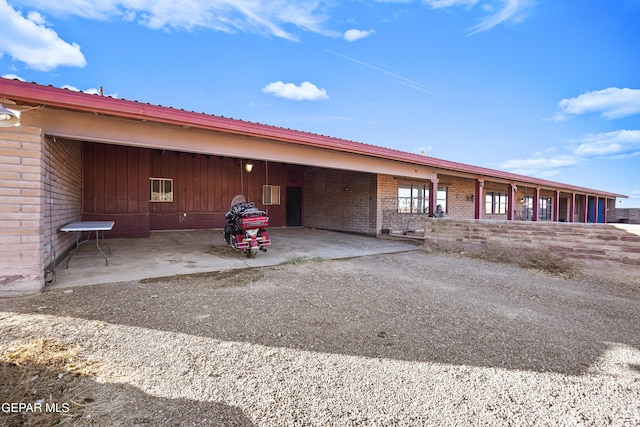 525 N Main St, Dell City, TX 79837 - back of property featuring brick siding, a carport, a metal roof, and driveway