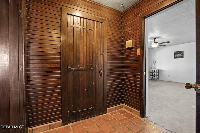 interior space featuring wood walls and ceiling fan