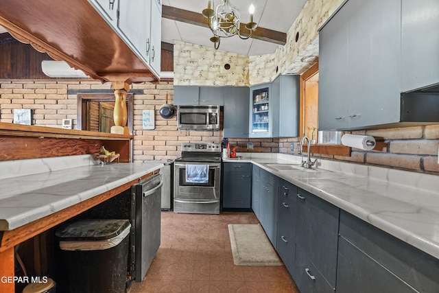 kitchen with light stone countertops, stainless steel appliances, lofted ceiling, and sink