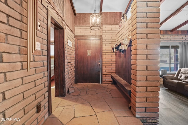 525 N Main St, Dell City, TX 79837 - entrance foyer featuring wood walls, brick wall, and a chandelier