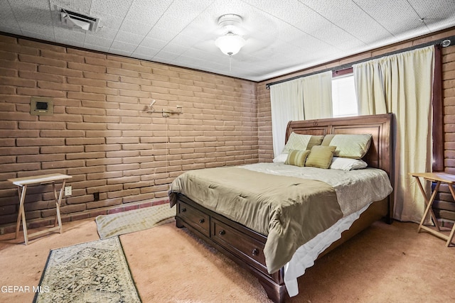 carpeted bedroom with brick wall