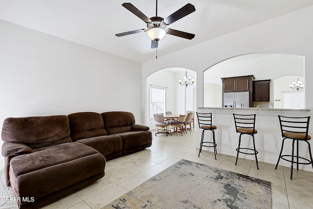 living room with ceiling fan with notable chandelier and light tile patterned floors