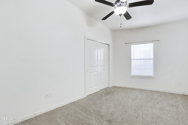 carpeted spare room featuring ceiling fan