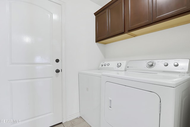 laundry room with cabinets, washing machine and dryer, and light tile patterned flooring