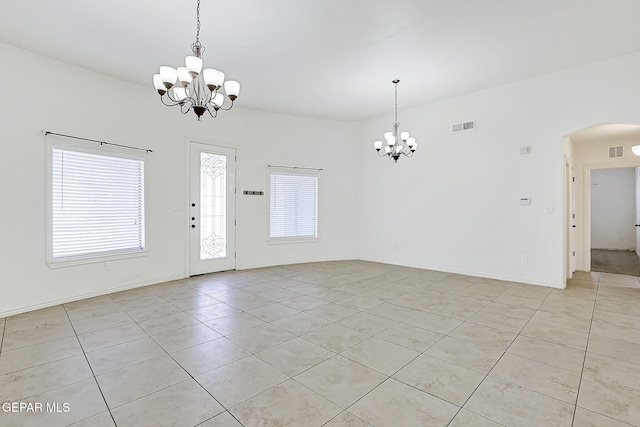 spare room featuring a chandelier and light tile patterned flooring