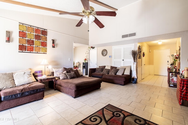 tiled living room featuring ceiling fan and high vaulted ceiling