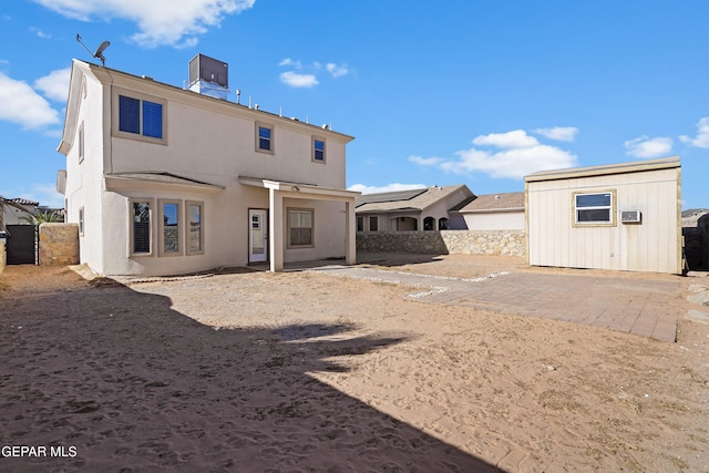 back of property featuring a storage shed