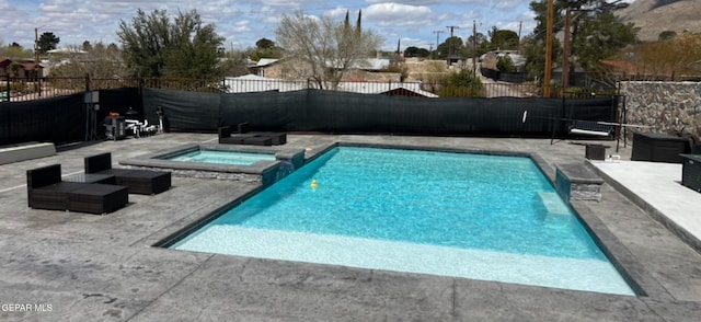 view of pool with an in ground hot tub and a patio