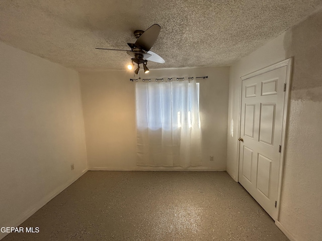 empty room featuring ceiling fan and a textured ceiling