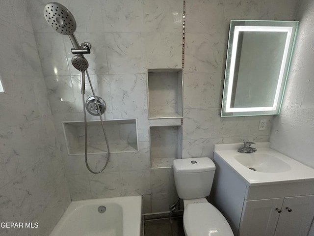 full bathroom featuring tiled shower / bath, vanity, and toilet