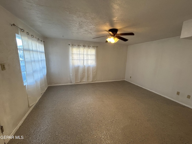 empty room featuring ceiling fan and a textured ceiling