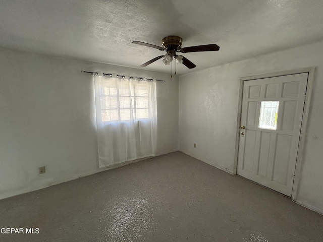 foyer featuring ceiling fan and a textured ceiling