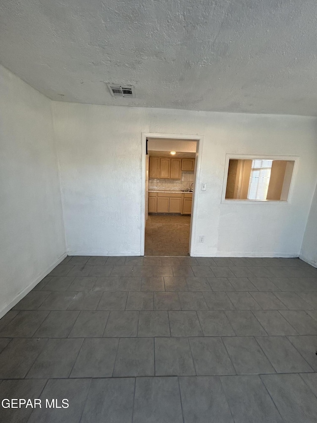 spare room with a textured ceiling