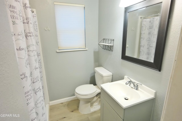 bathroom featuring toilet, vanity, a shower with curtain, and hardwood / wood-style flooring