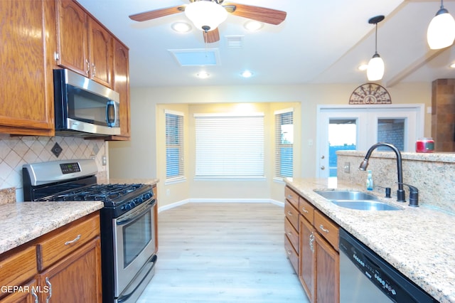 kitchen featuring light hardwood / wood-style floors, stainless steel appliances, decorative backsplash, decorative light fixtures, and sink