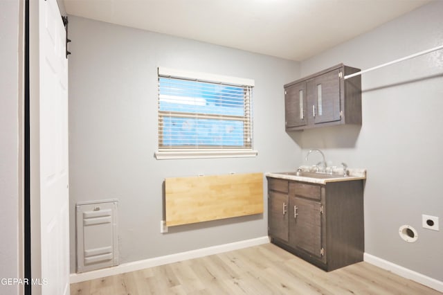 laundry room featuring light wood-type flooring, electric dryer hookup, and sink