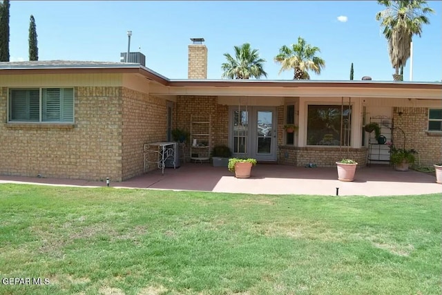 rear view of property featuring a yard and a patio