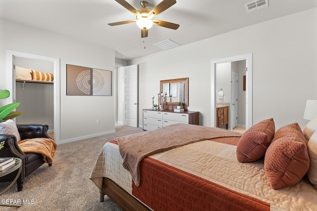 bedroom featuring ensuite bathroom, a spacious closet, ceiling fan, light carpet, and a closet