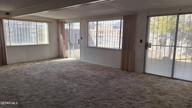 carpeted spare room with a textured ceiling