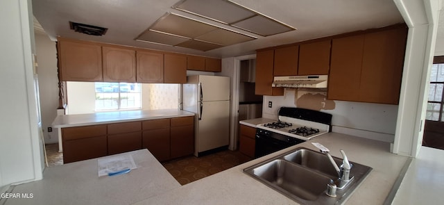 kitchen featuring kitchen peninsula, white appliances, and sink