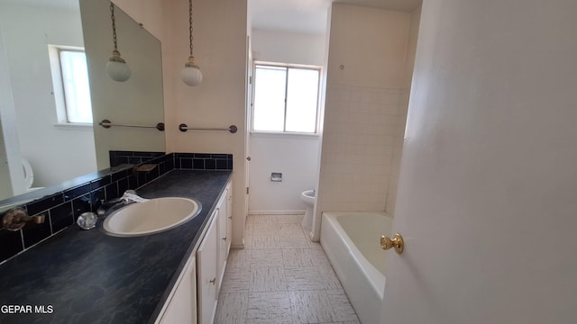 bathroom with decorative backsplash, vanity, and toilet