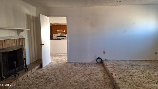 laundry room featuring carpet flooring, a textured ceiling, and a brick fireplace