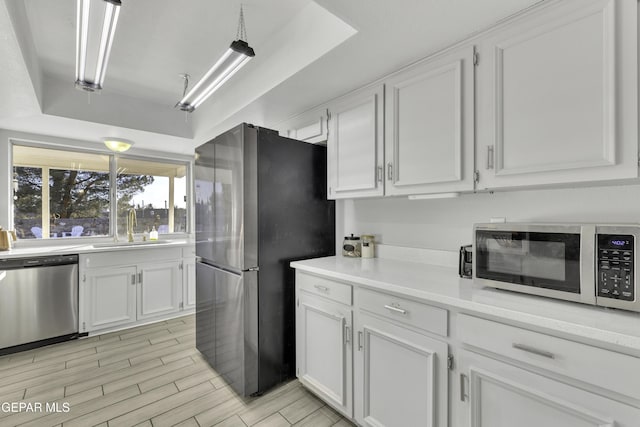 kitchen featuring white cabinets, appliances with stainless steel finishes, and sink