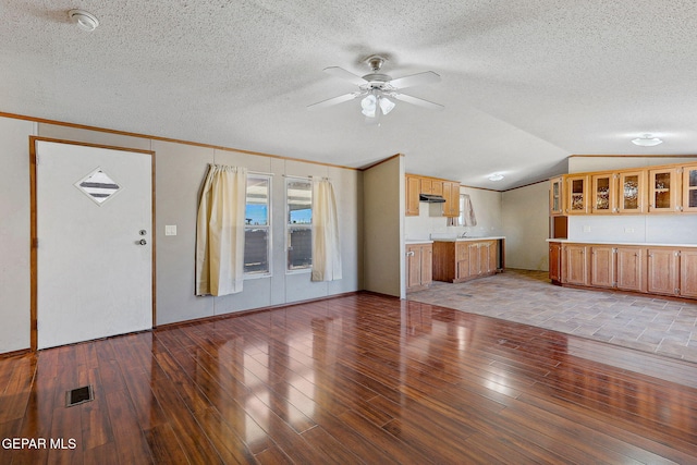 unfurnished living room featuring a textured ceiling, ceiling fan, light hardwood / wood-style flooring, and lofted ceiling