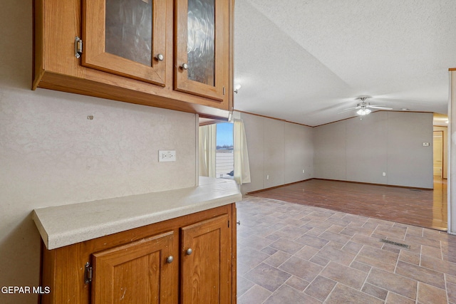 kitchen with ceiling fan and a textured ceiling