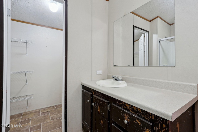 bathroom with crown molding, vanity, and a textured ceiling