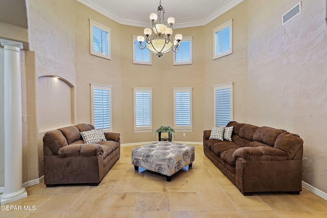 living room featuring an inviting chandelier, ornate columns, and crown molding