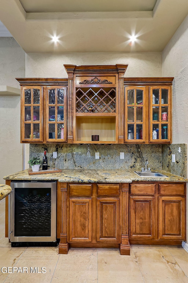 bar with light stone counters, wine cooler, tasteful backsplash, and sink